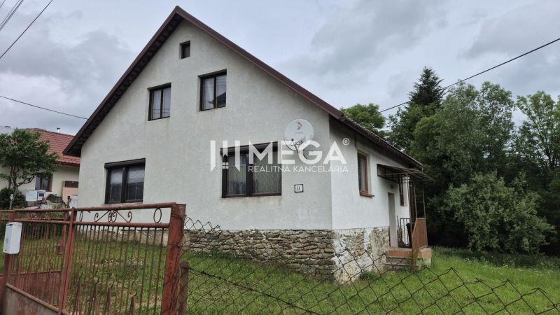 Ein Einfamilienhaus in Zboj mit einem Steinfundament und einem Garten, umgeben von Grün.