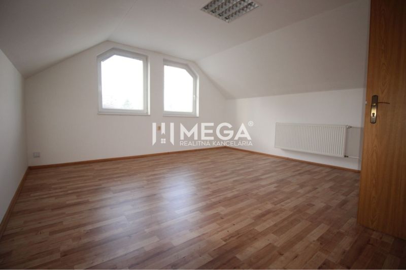 Ein Raum mit einem Holzboden und einer schrägen Decke in Geschäftsräumen.