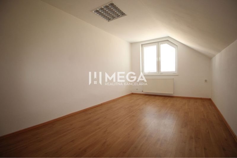 Ein Raum mit einem Holzboden und einem Dachfenster in Geschäftsräumen.