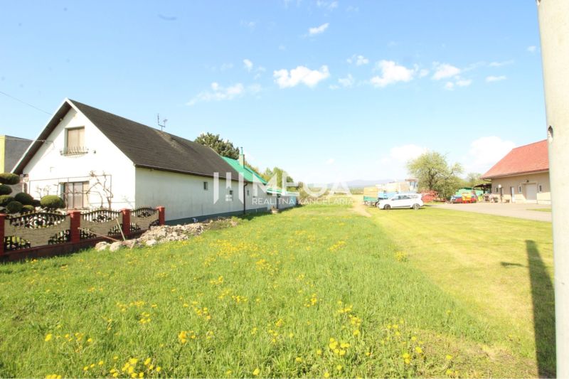 Ein Einfamilienhaus mit zwei Gebäuden und einem blühenden Rasen im Dorf Sačurov. Grundstücke - Wohnen.
