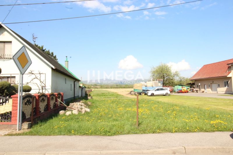 Grundstücke - Wohnen in Sačurov mit Häusern, Rasen und Verkehrsschild.
