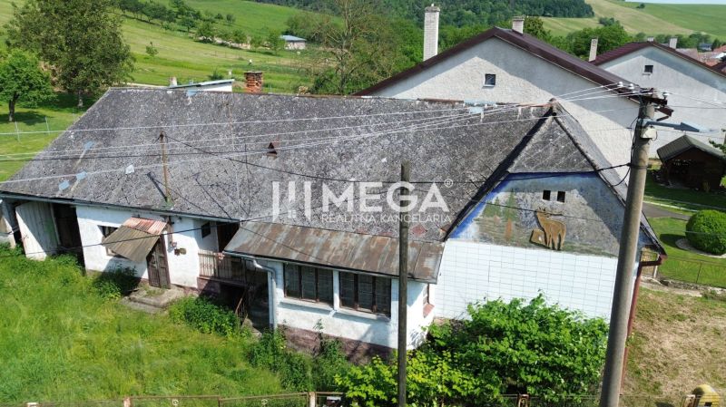 Ein altes Gebäude auf Wohnbaugrundstücken in Ondavské Matiašovce, umgeben von Grün.