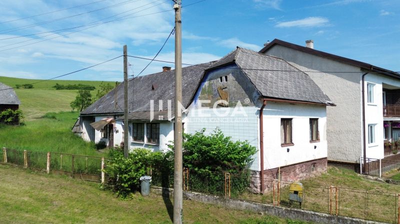 Ein älteres Haus mit Holzelementen im grünen Ondavské Matiašovce, ideal für Grundstücke - Wohnen.