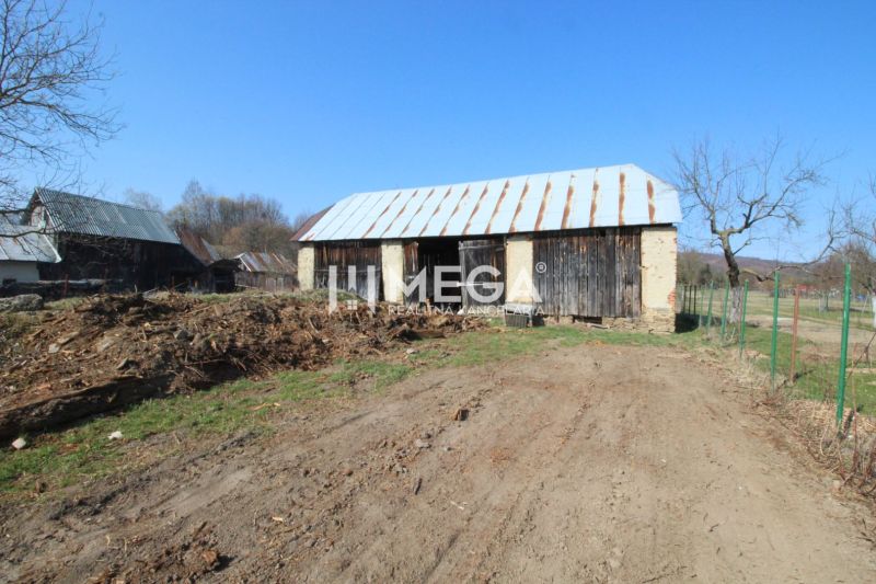 Ein Einfamilienhaus in Zbojná mit einem Holzschuppen und der umliegenden Natur auf dem Land.