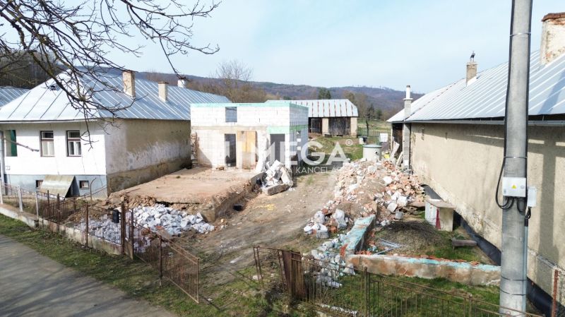 Ein Einfamilienhaus in Zbojné in Renovierung, die Umgebung mit Haufen von Baumaterialien.