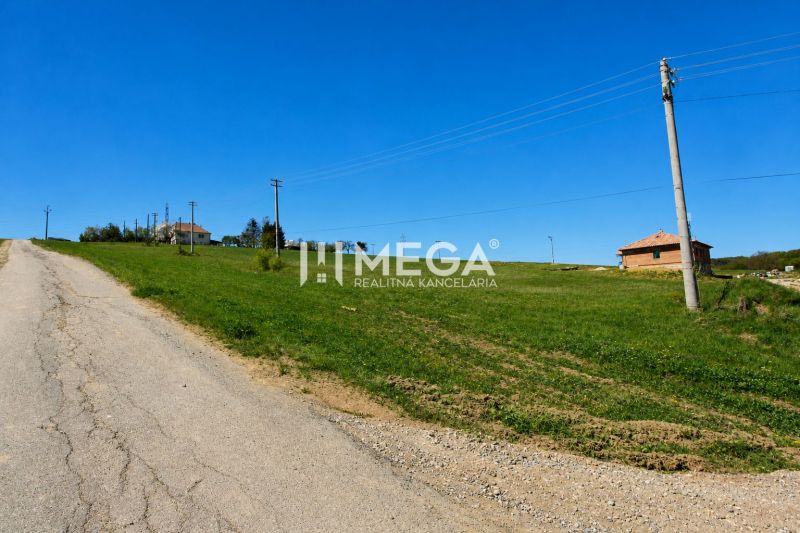 Grundstücke - Wohnen in Víťazovce mit einer weitläufigen Wiese und einer nicht gepflegten Asphaltstraße.