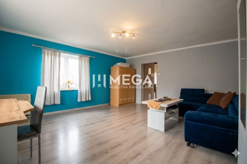 Wohnzimmer in einem Einfamilienhaus mit Holzboden und blauer Wand.
