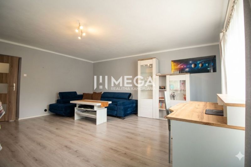 Wohnzimmer in einem Einfamilienhaus mit einem blauen Sofa und einem Boden in Holzoptik.