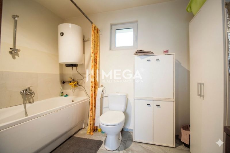Badezimmer in einem Einfamilienhaus mit sanitären Einrichtungen und Aufbewahrungsschränken.