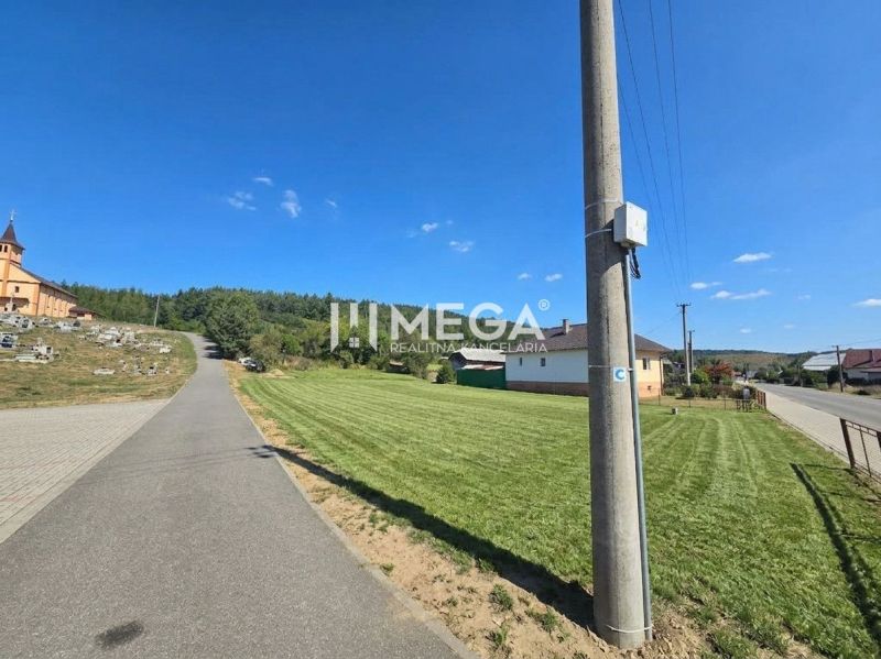 Straße in Slovenská Volová mit Grünflächen, Häusern und Kirche, Grundstücke - Wohnen.