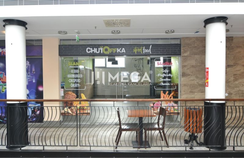 Obchodsräume mit Street-Food-Werbung in einem Einkaufszentrum.