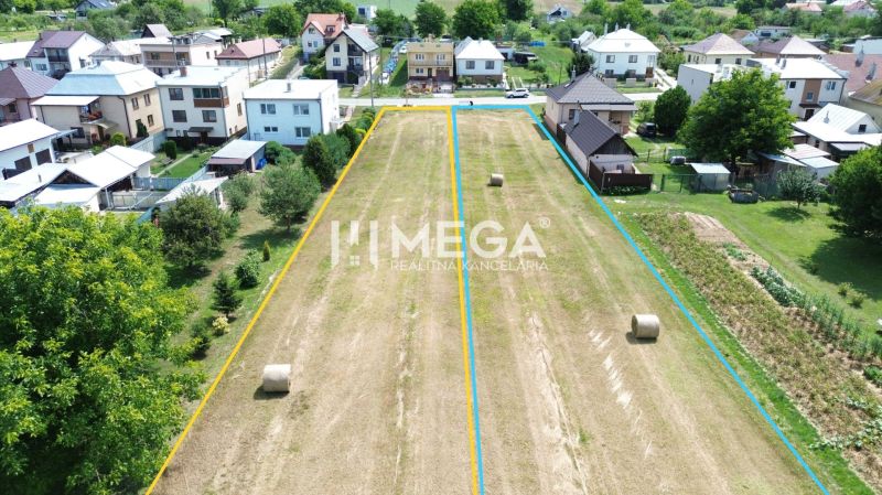 Grundstücke - Wohnen in Jasenov, umgeben von Häusern und grünen Bäumen.