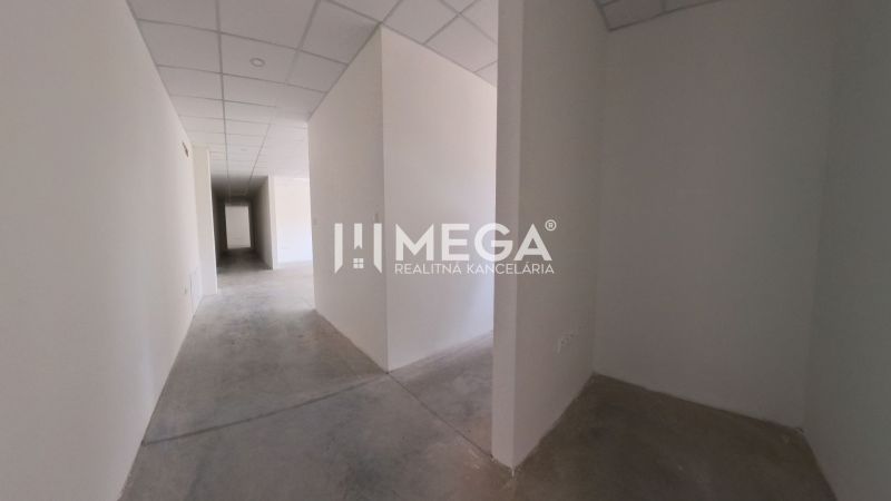 Der Flur im Büro mit weißen Wänden, Betonboden, abgehängter Decke.