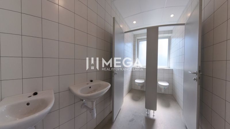 Sanitäreinrichtungen mit Waschbecken und WC in Büros, Fliesen an den Wänden.