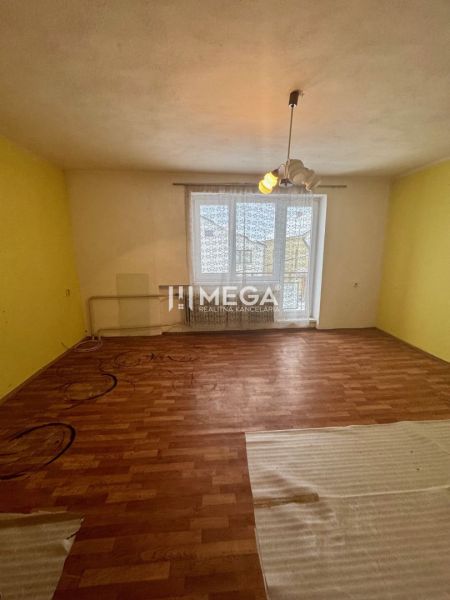 Ein Zimmer in einem Einfamilienhaus mit einem Holzboden und einer gelben Wand.
