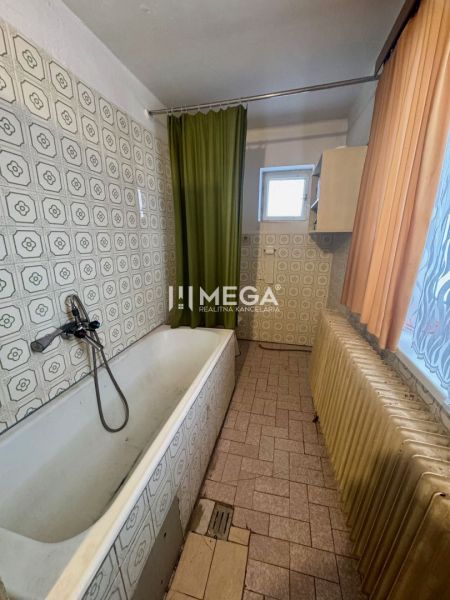 Ein Badezimmer in einem Einfamilienhaus mit einer Badewanne und dekorativen Fliesen.
