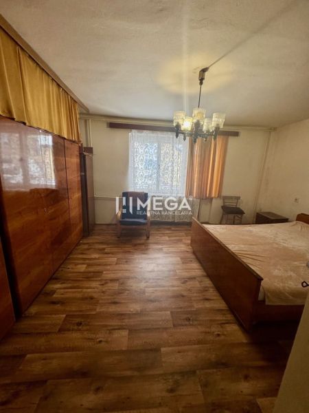 Schlafzimmer im Einfamilienhaus mit Holzboden, Kronleuchter und Schrank.