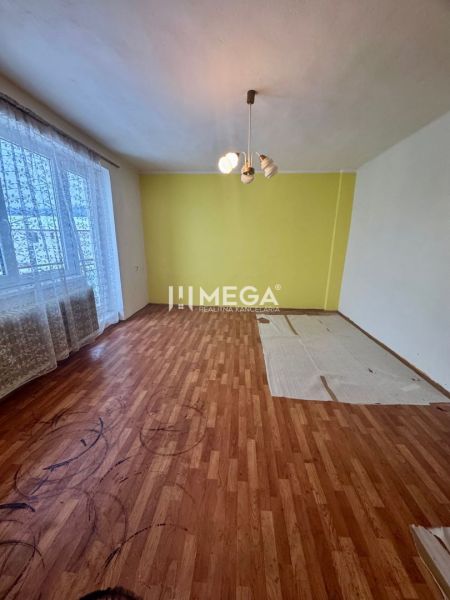 Ein Zimmer mit einem Holzboden und einer gelben Wand in einem Einfamilienhaus.