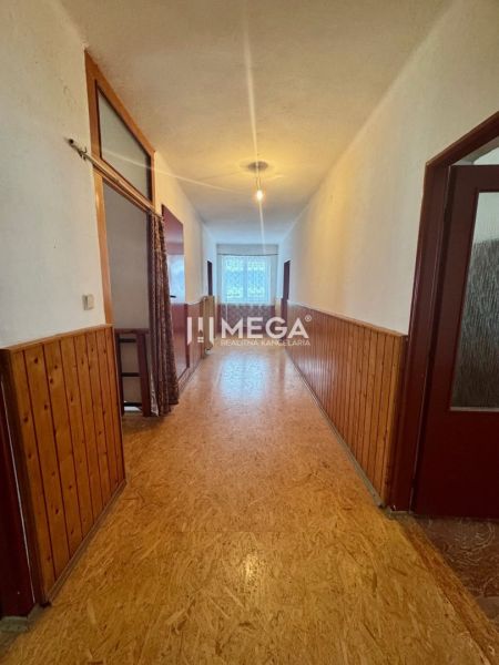 Flur mit einer Wand aus Paneelen und einem Boden mit Holzdekor in einem Einfamilienhaus.