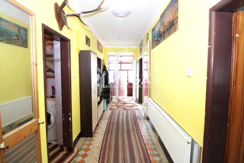 Flur in einem Einfamilienhaus mit Heizkörper, Teppichen und Wanddekorationen.