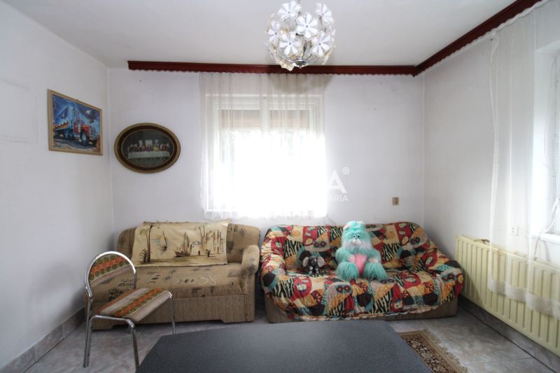 Wohnzimmer in einem Einfamilienhaus mit einem bunten Sofa und dekorativer Beleuchtung.