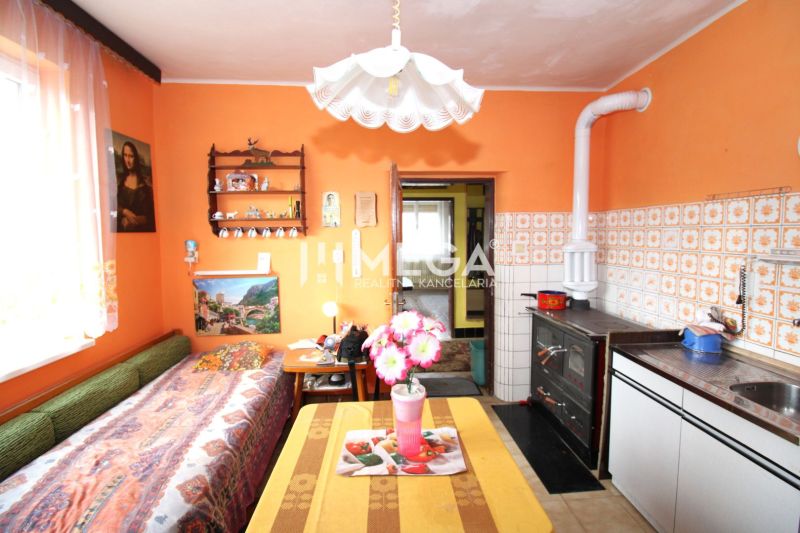 Ein Einfamilienhaus mit orangefarbenen Wänden, einem Kachelofen und Dekorationen, gemütliches Interieur.