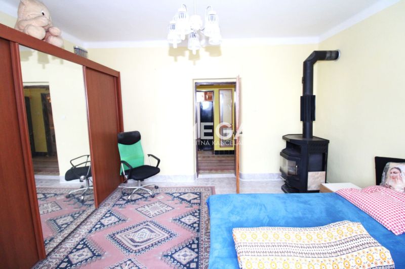 Ein Zimmer in einem Einfamilienhaus mit Teppichen, einem Kamin und Spiegeltüren am Schrank.