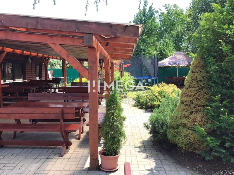 Vranov nad Topľou, Budovateľská: Gastronomische Räumlichkeiten mit Holzsitzgelegenheiten und Grün auf der Terrasse.