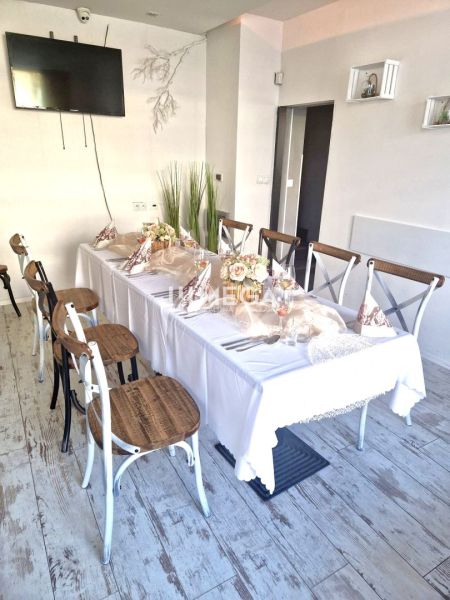 Ein gedeckter Tisch mit Dekorationen, ein Boden mit Holzdekor, Stühle in Gastronomiebereichen.