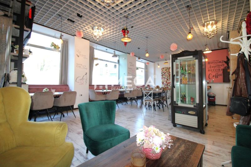 Das Innere eines Cafés mit Holzboden, bequemen Sesseln und Dekorationen an der Decke.
