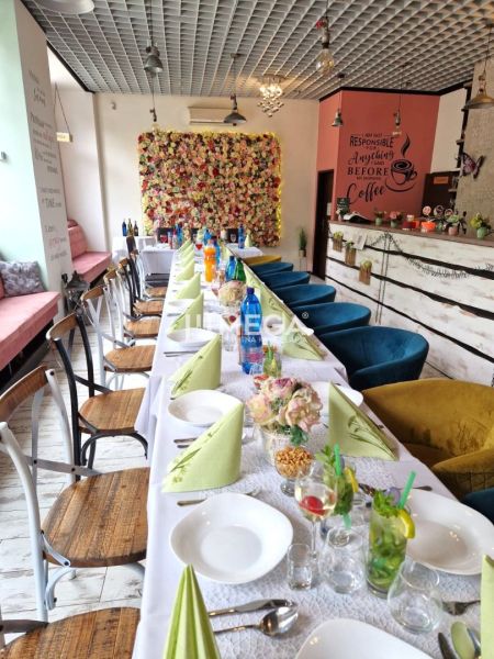 Innenraum von Gastronomiebereichen mit dekorativer Wand und gedecktem Tisch mit bunten Servietten.