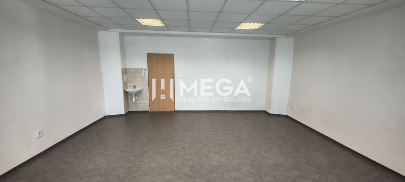 Leere Büroräume mit Waschbecken und dunklem Boden in Holzoptik.