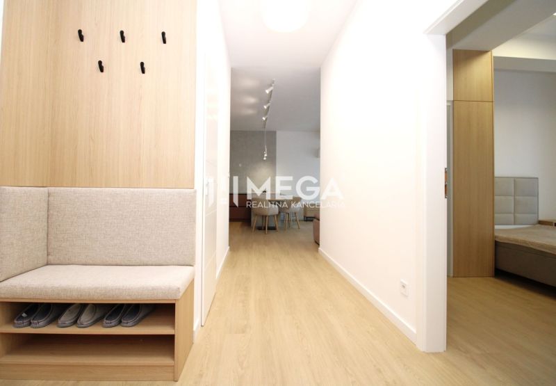 Flur in einer 3-Zimmer-Wohnung mit Holzboden und eingebauter Sitzgelegenheit.