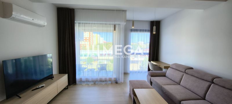 Wohnzimmer in einer 3-Zimmer-Wohnung mit einem bequemen Sofa und großen Fenstern.