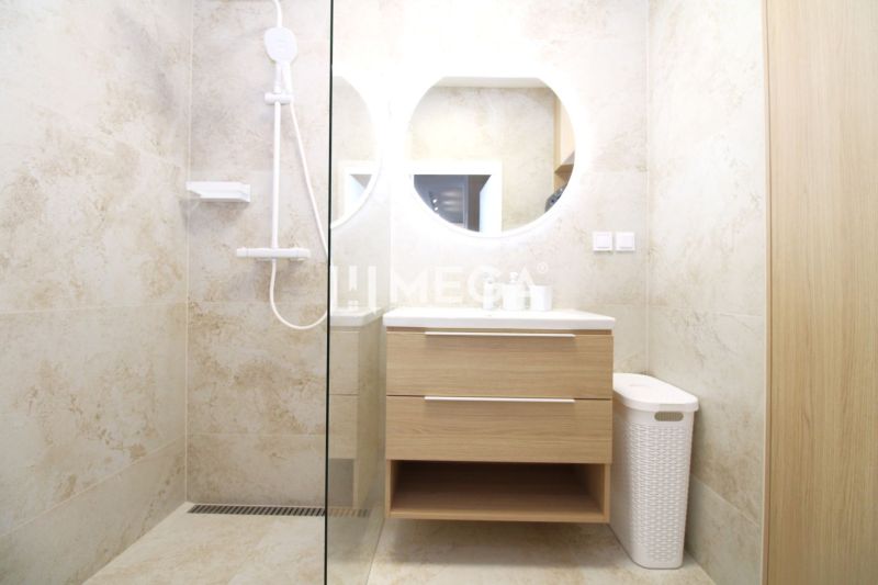 Badezimmer mit Dusche und Holzelementen in einer 3-Zimmer-Wohnung.