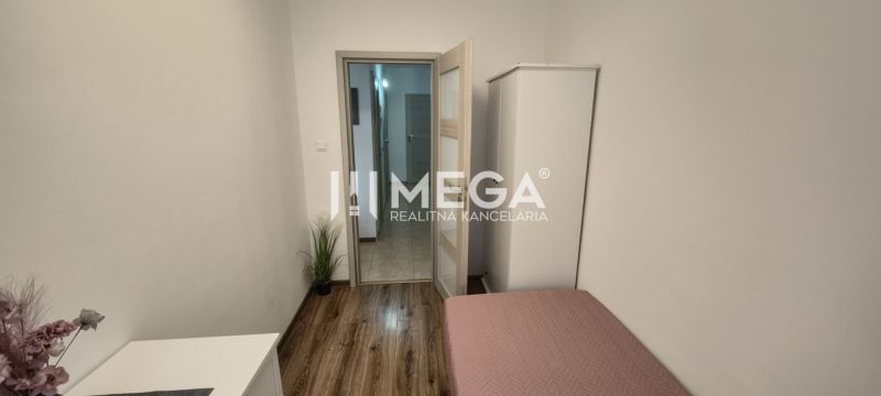 Helles Zimmer in einer 3-Zimmer-Wohnung mit Bett, Schrank und Holzboden.