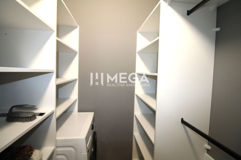Garderobe in einer 3-Zimmer-Wohnung mit Regalen und Waschmaschine.