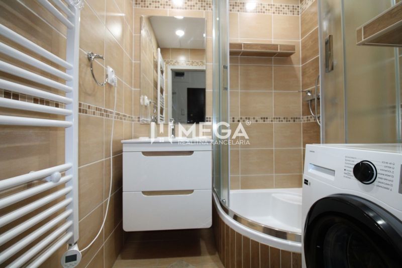 Badezimmer in einer 3-Zimmer-Wohnung mit Duschkabine und Waschmaschine, Fliesen mit Naturdekor.
