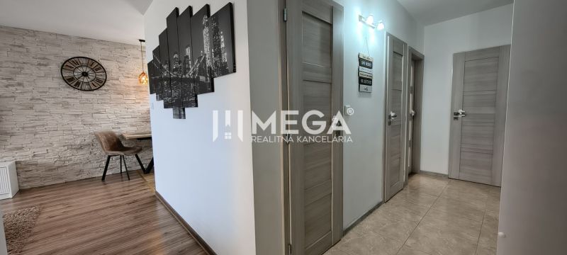 Innenraum einer 3-Zimmer-Wohnung mit einer Wand aus Steinverkleidung und einem Boden in Holzoptik.