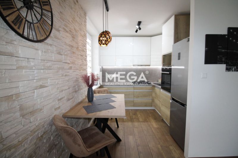 Küche in einer 3-Zimmer-Wohnung mit Holzboden und Steinverkleidung.