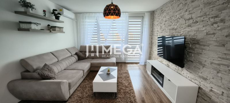 Wohnzimmer in einer 3-Zimmer-Wohnung mit einer Eckcouch und einem Boden in Holzoptik.