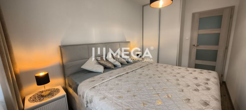 Schlafzimmer in einer 3-Zimmer-Wohnung mit einem bequemen Bett und einer Lampe auf dem Nachttisch.