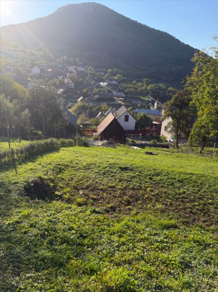 Ein Baugrundstück in Košecké Podhradie, umgeben von Natur und Häusern, unter den Gipfeln der Berge.
