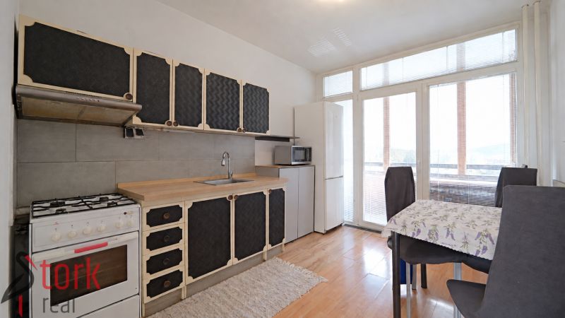 Küche in einer 3-Zimmer-Wohnung mit Holzboden und Essecke.