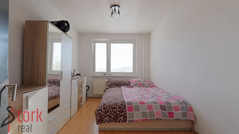 Schlafzimmer in einer 3-Zimmer-Wohnung mit einem Schrank und einem Boden in Holzoptik.
