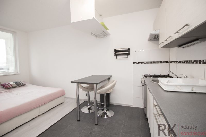 Küche und Essbereich mit Sofa in einer 2-Zimmer-Wohnung, Boden mit Holzdekor.