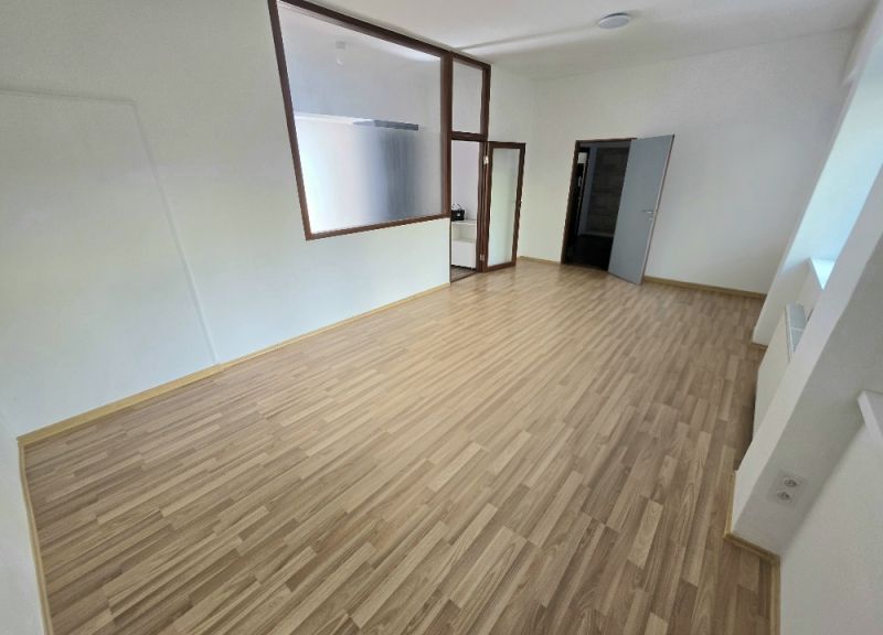 Helles Zimmer mit Holzboden in einer 2-Zimmer-Wohnung.