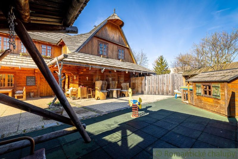Ein Holzfamilienhaus in Machulince mit einem Kinderspielplatz und Holzmöbeln.