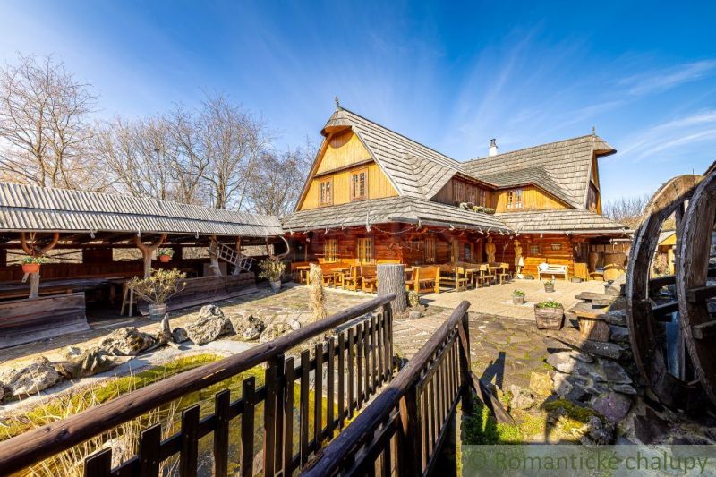 Ein Holzfamilienhaus in Machulince mit Terrasse und Wassermühlrad.