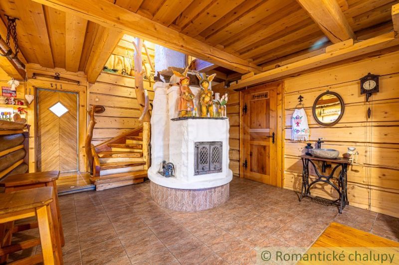 Innenraum eines Einfamilienhauses mit Kamin, Treppe und Boden in Holzoptik.